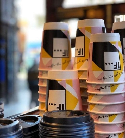 IF Bar Call Lane Stacked Coffee Cups Bokeh Background Stacks of colorful paper cups with modern design on a counter at IF Bar – Call Lane.