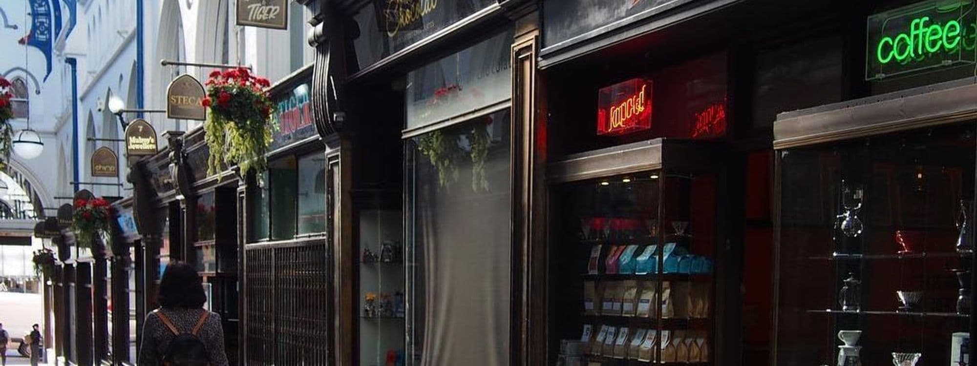 Exterior view of Kapow Coffee shop front with neon sign, situated in the historic Thorntons Arcade, showcasing traditional architecture and vibrant storefronts.