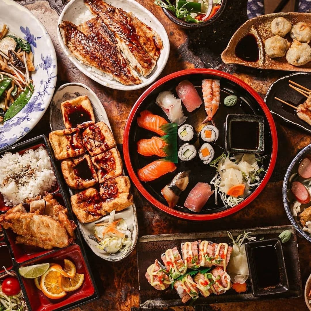 Little Tokyo Authentic Japanese Cuisine Delicious Sushi Platter Assorted traditional Japanese dishes on a table in Little Tokyo, including sushi, sashimi, grilled fish, and skewers.