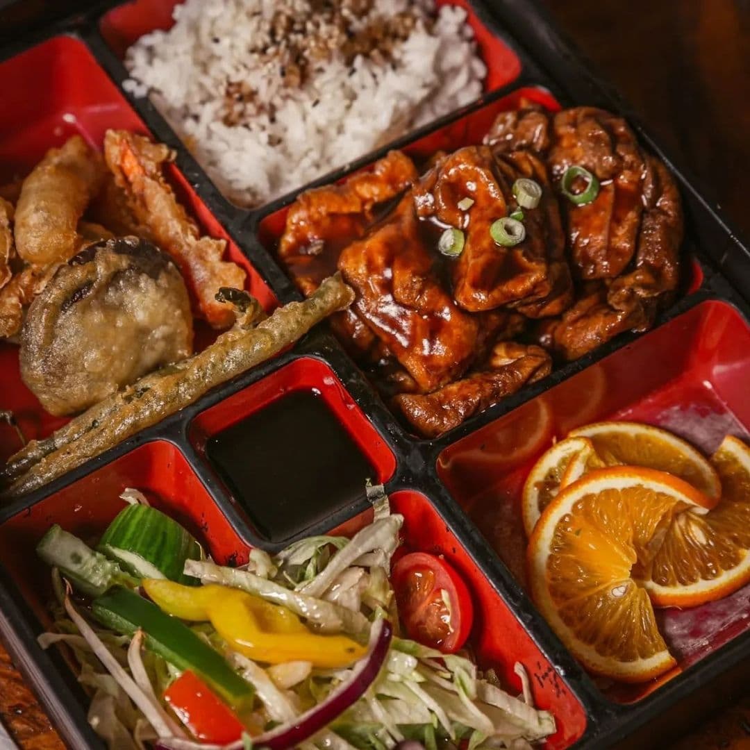 LittleTokyo_BentoBox_DeliciousCuisine_ColorfulPresentation Japanese bento box with rice, teriyaki chicken, tempura, salad, and orange slices served in Little Tokyo.