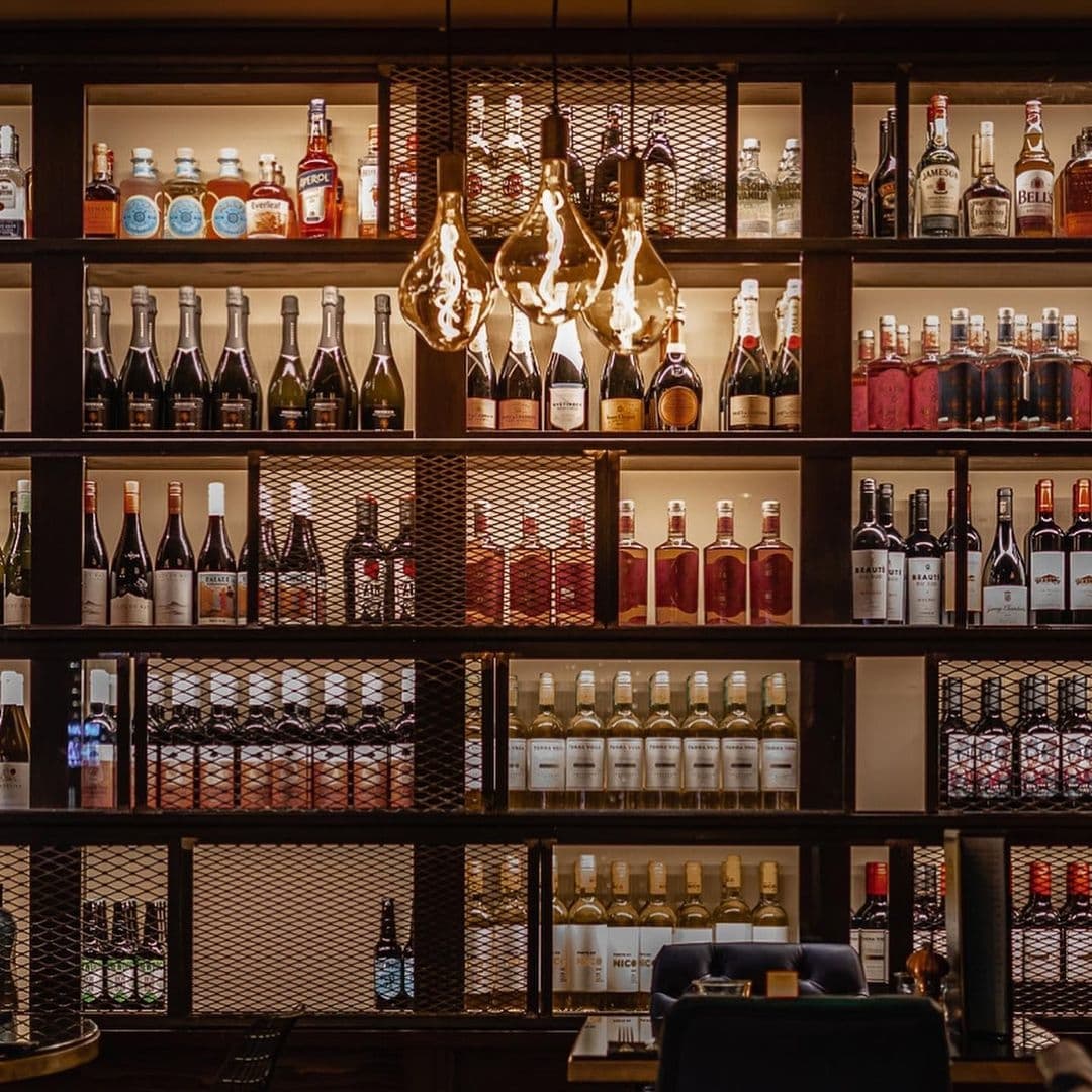 The Cut and Craft Elegant Bar Shelves Liquor Display Elegant backlit bar shelves stocked with an assortment of bottles at The Cut & Craft.