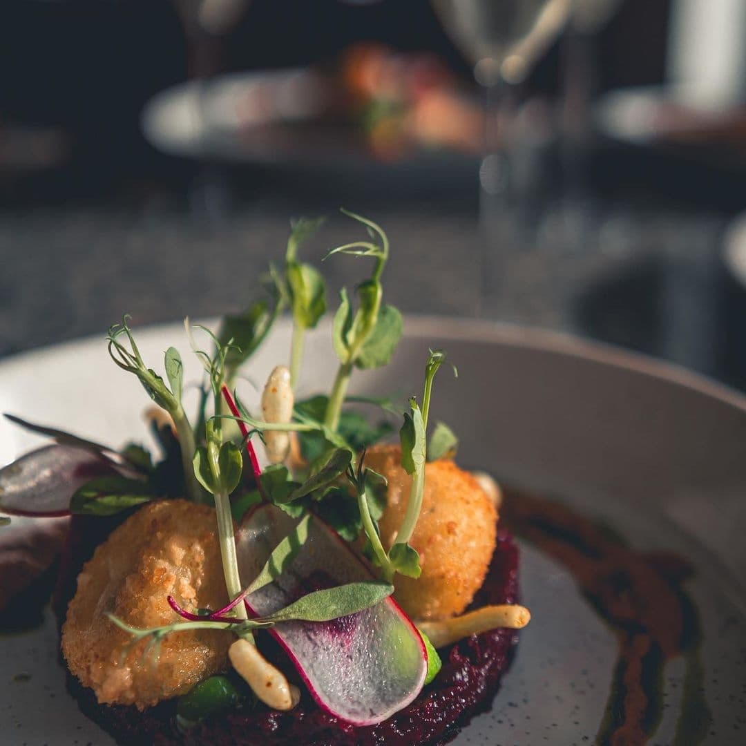 The Whitehall Restaurant Bar Gourmet Dish Presentation Gourmet dish with golden-brown croquettes and fresh greens served at The Whitehall Restaurant & Bar.