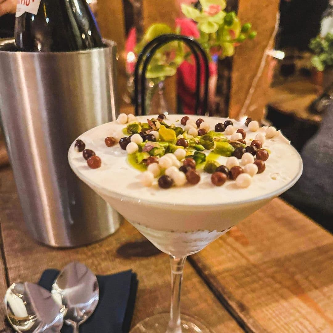 WOOD FIRE DINE Pizzeria Creamy Dessert Cocktail Garnish Gourmet dessert in a martini glass garnished with pistachios and chocolate beads at WOOD FIRE | DINE Pizzeria.