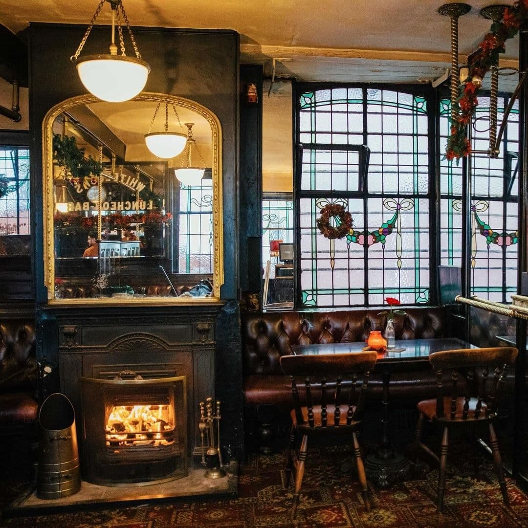 Whitelocks Ale House Cozy Fireplace Vintage Interior Interior of Whitelock's Ale House with cozy seating, a lit fireplace, stained glass windows, and vintage decor.