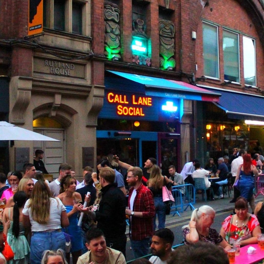 Call Lane Social Nightlife Crowd Evening Entertainment Vibrant street scene outside Call Lane Social with people socializing and neon signage above.