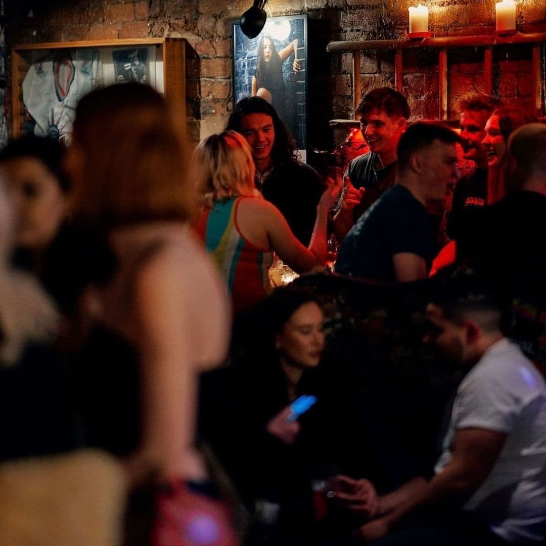 The East Village Vibrant Nightlife Bar Crowd Social Vibrant nightlife scene with people socializing in a dimly lit bar in The East Village.