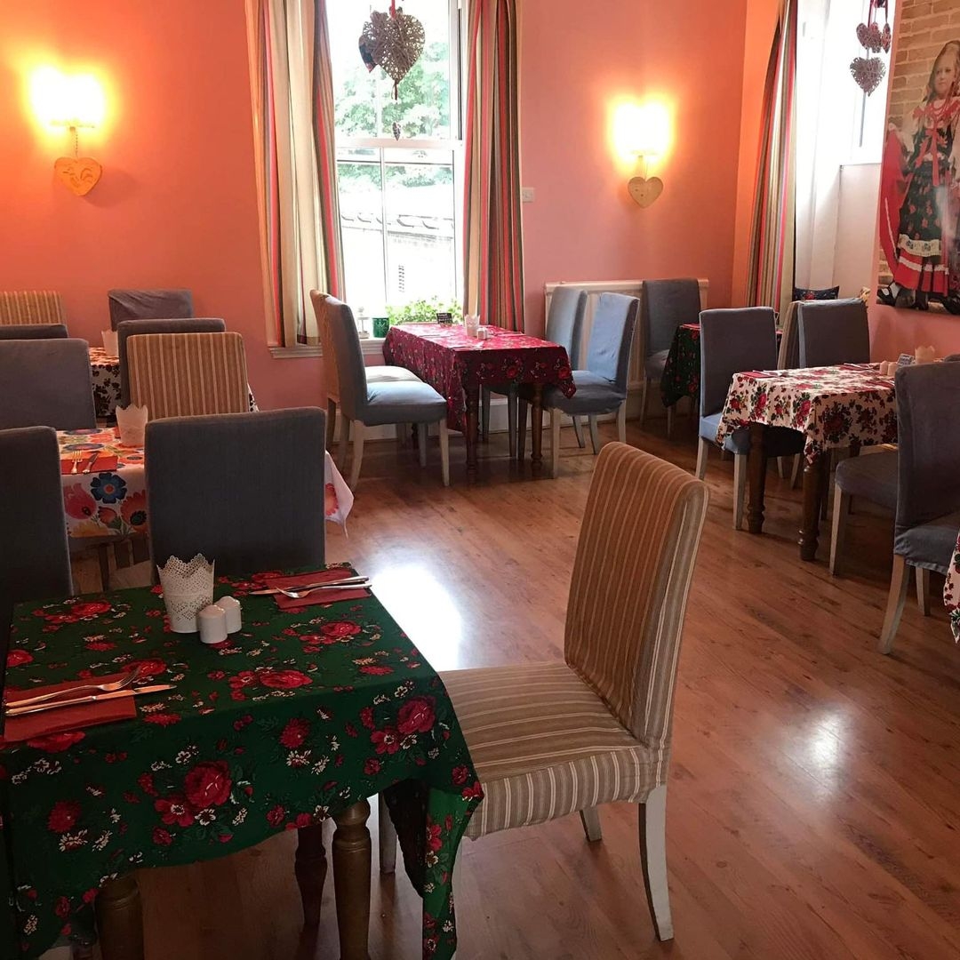 Cracovia_Taste_of_Poland_Cozy_Traditional_Dining_Area Interior of Cracovia Taste of Poland restaurant showing a cozy dining space with patterned tablecloths, comfortable chairs, and warm lighting.