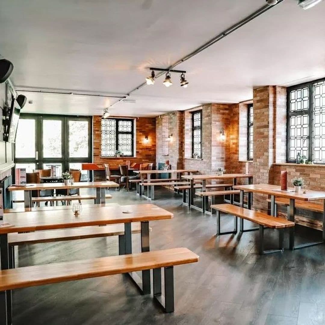 Parkside Tavern Interior Brick Walls Wooden Furniture Interior of Parkside Tavern with wooden tables and benches, brick walls, large windows, and stylish lighting fixtures.