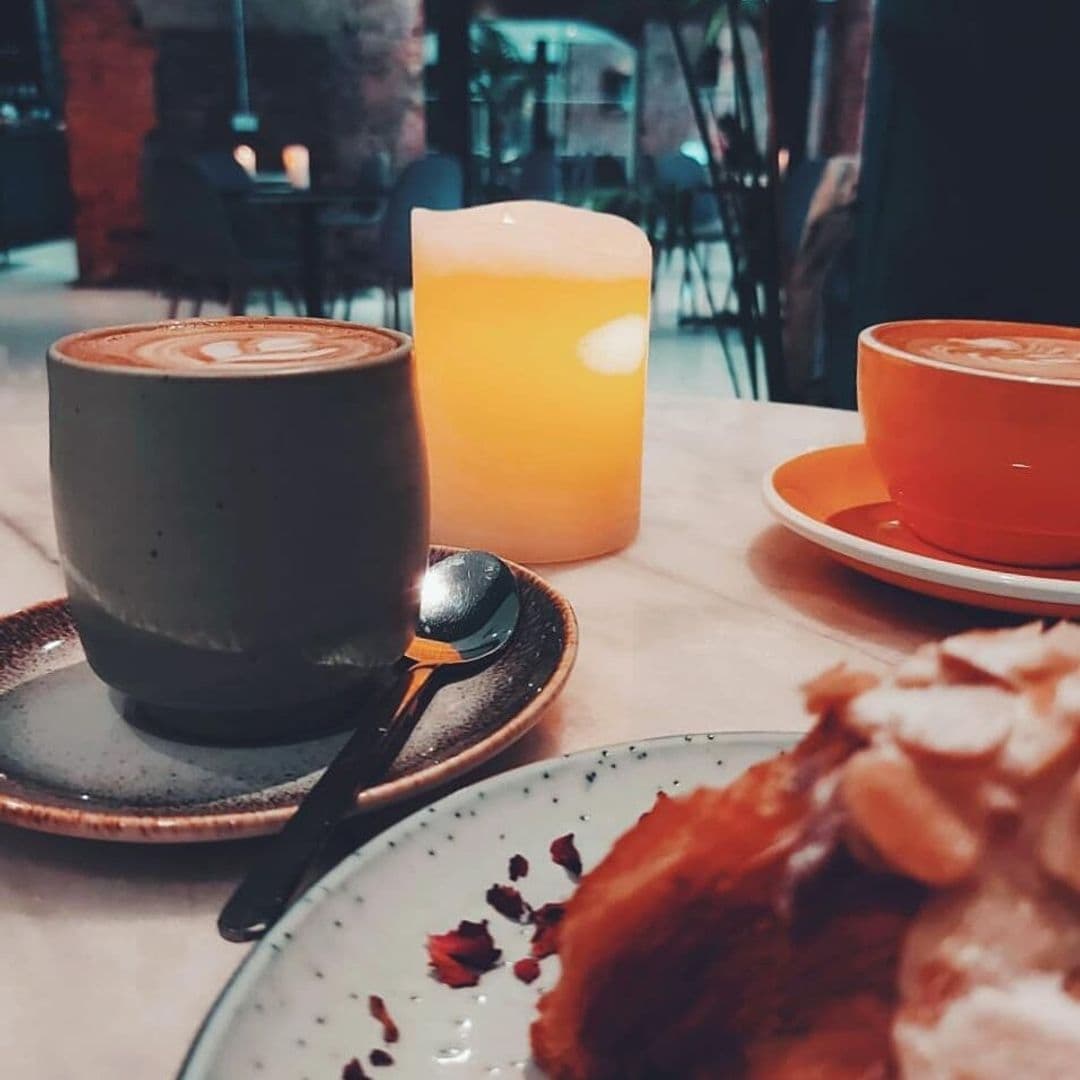 Wolfox Coffee at ZAVIYA Coffee Bar Restaurant Cappuccino Dessert Ambiance Artfully crafted latte with latte art, refreshing orange juice, and a vibrant cappuccino on rustic ceramic tableware, accompanied by a delectable pastry, at Wolfox Coffee at ZAVIYA COFFEE Bar & Restaurant.