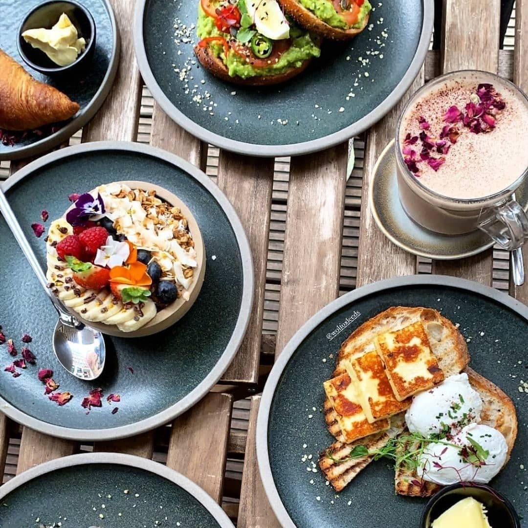 Wolfox Coffee at ZAVIYA Coffee Bar Restaurant Gourmet Brunch Spread Gourmet breakfast spread at Wolfox Coffee at ZAVIYA COFFEE Bar & Restaurant featuring avocado toast, a smoothie bowl with fresh fruit, poached eggs on toast, a croissant, and a cup of hot chocolate.