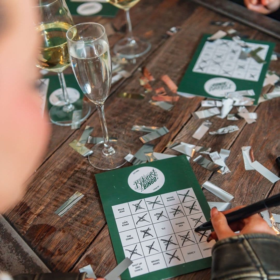 The Botanist Trinity Bingo Game Social Event Champagne "Guest enjoying a game of bingo with a filled card and champagne glasses at The Botanist Trinity."