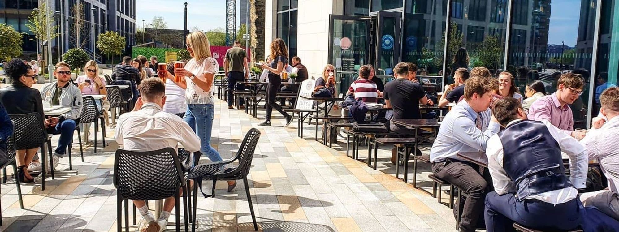 Outdoor seating at Sociable Folk with people enjoying drinks and conversation on a sunny day.