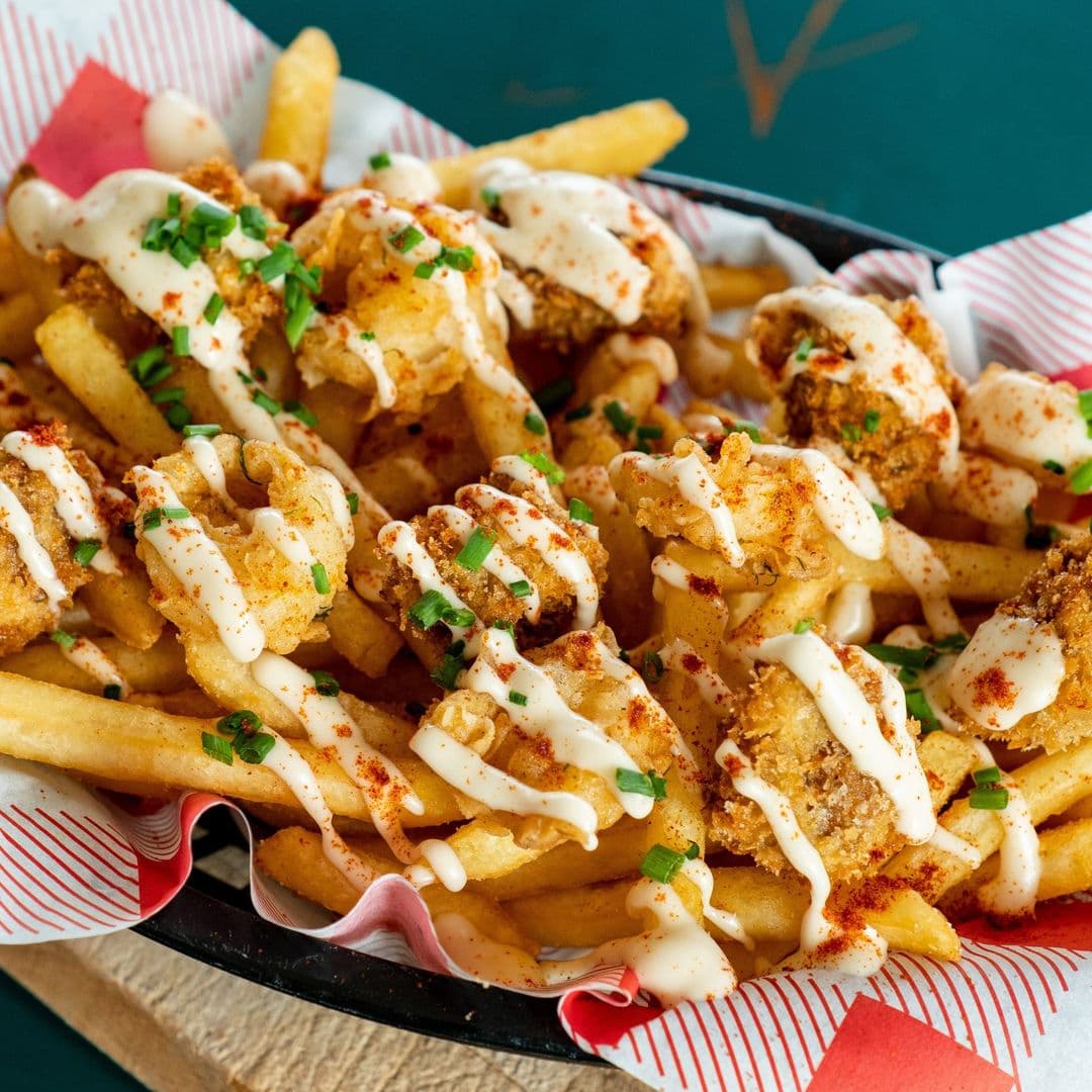 The Old Red Bus Station Gourmet Loaded Fries Appetizing Food Dish Crispy loaded fries with creamy sauce and garnishes served at The Old Red Bus Station.