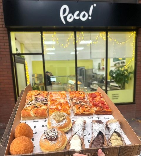 POCO Sicilian Street Food The Calls Assorted Italian Pastries and Pizza Assorted Sicilian street food from POCO Sicilian Street Food – The Calls, featuring a selection of pizza slices and traditional pastries displayed in a cardboard box with the restaurant storefront and sign in the background.