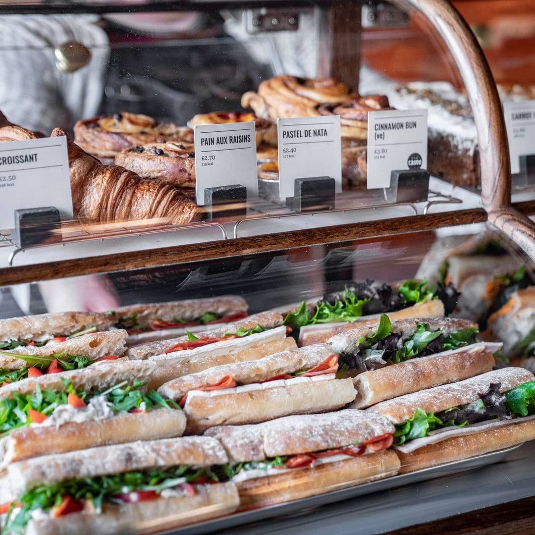 200 Degrees Coffee Shop delicious sandwiches bakery pastries fresh Delicious selection of pastries and sandwiches displayed in a glass case at 200 Degrees Coffee Shop. The assortment includes croissants, pain aux raisins, pastel de nata, and various sandwiches filled with fresh greens and tomatoes.