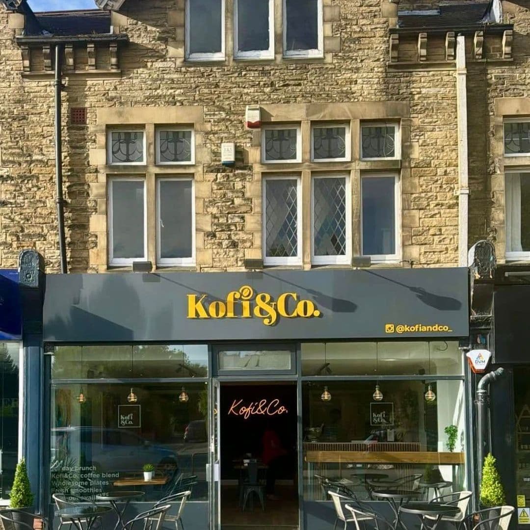 Kofi Co Roundhay coffee shop exterior cafe architecture Alt text: "Exterior view of Kofi&Co – Roundhay, featuring a stone building with large windows and a modern sign. The café has outdoor seating and a welcoming entrance."
