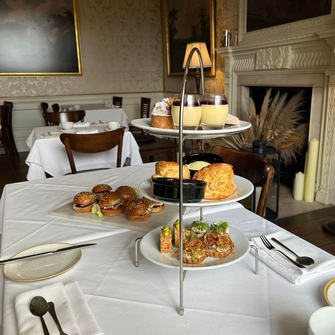Terrace Tearoom afternoon tea gourmet dining elegant setting A beautifully arranged afternoon tea display at the Terrace Tearoom, featuring a tiered stand with savory sandwiches, scones, and desserts. The setting includes elegant tableware and a cozy atmosphere with tasteful decor in the background.