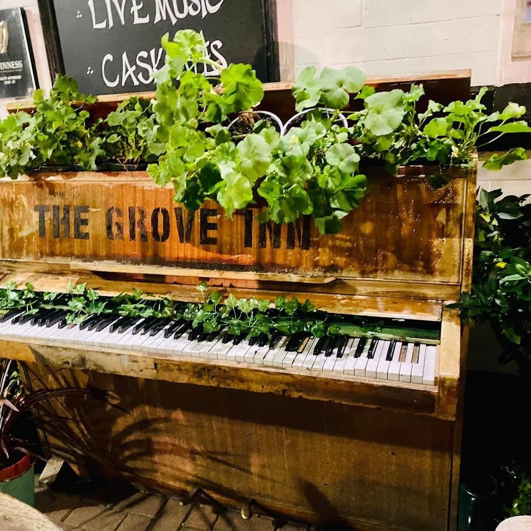 Charming Piano Planter at The Grove Inn Weathered piano adorned with lush green plants, creating a cozy, inviting atmosphere at The Grove Inn.