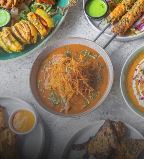 card-1772627819380 Delhi Wala Food curry, kebabs, and green chutney spread