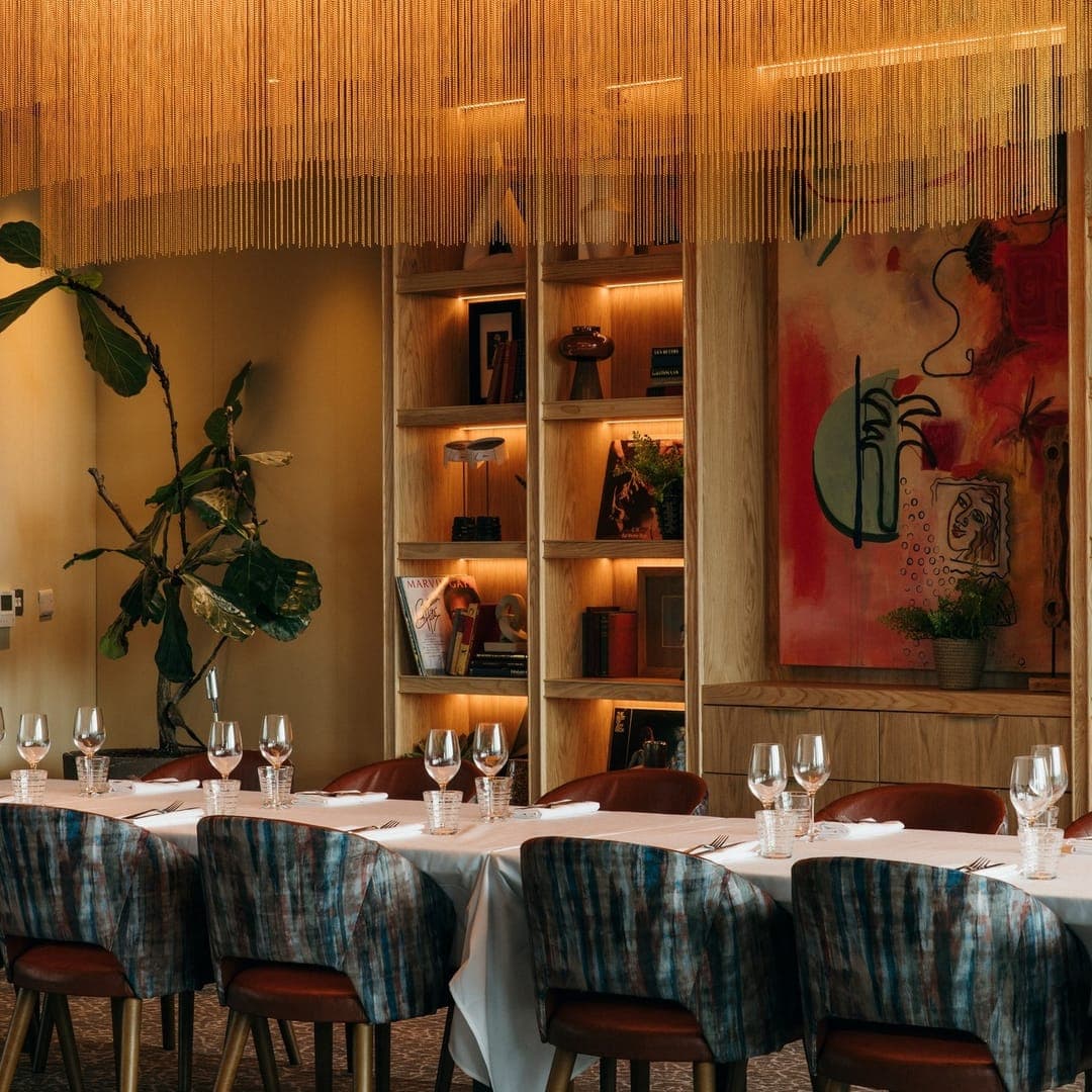 gallery-1772619295963 Private dining room interior at CrowdedHouse Leeds with warm lighting and set tables