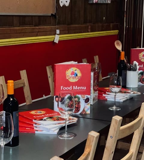 sri-non-thai-street-food-card Sri Non Thai Street Food dining room with red walls, laid tables and Srimon food menus