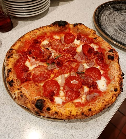 vesuvius-card VESUVIUS — Neapolitan pizza with charred crust viewed from above