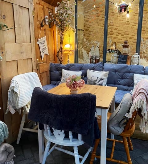 miracle-cafe-cosy-seating-corner Cosy seating corner at Miracle cafe with blue cushioned sofas, fairy lights and wooden table