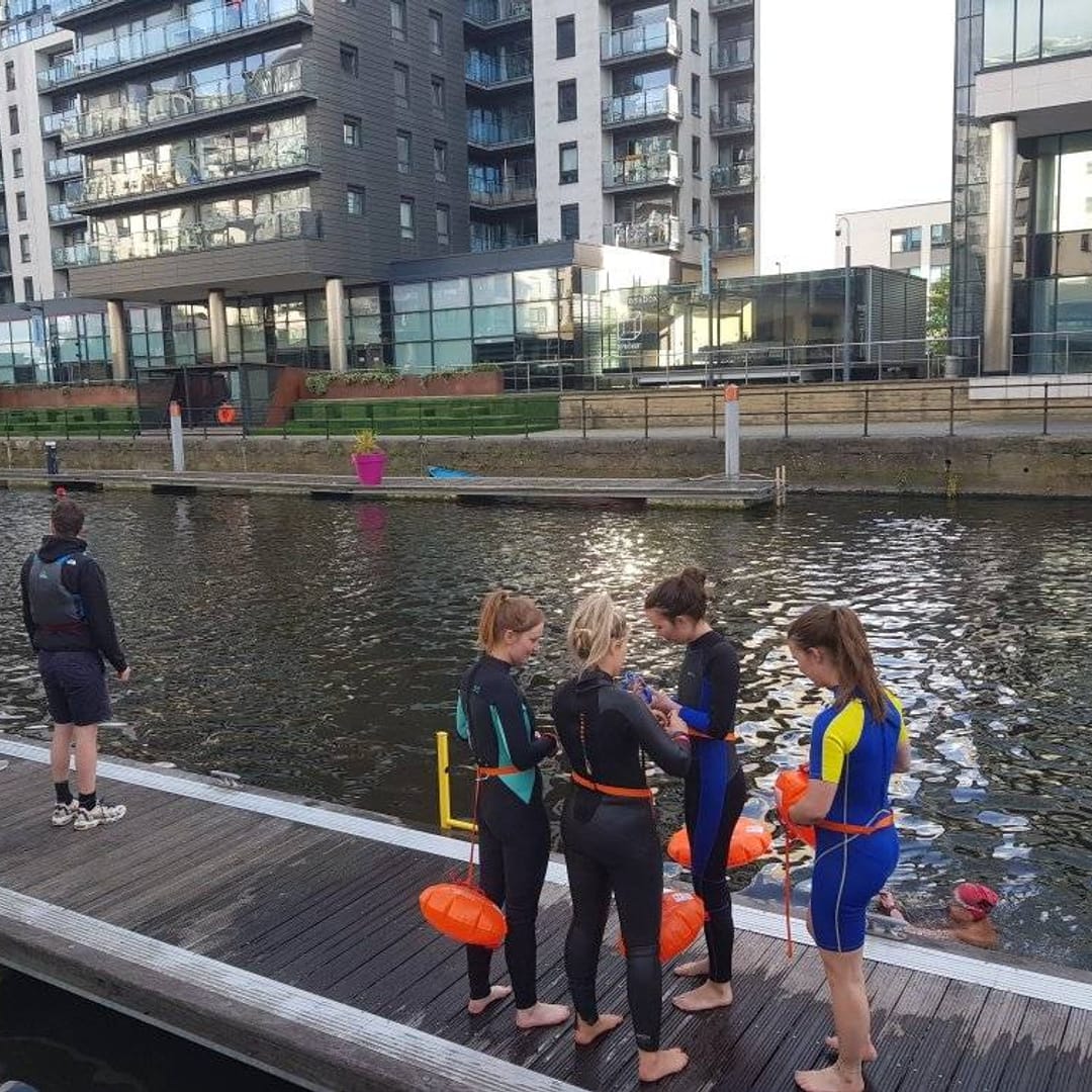 Open-water swimming session at Leeds Dock with safety paddlers.